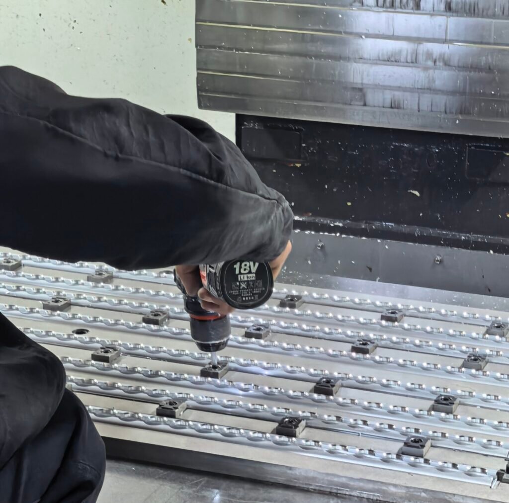 Factory worker machining aluminum L‑track and E‑track rails for cargo securing system, manufacturing workshop